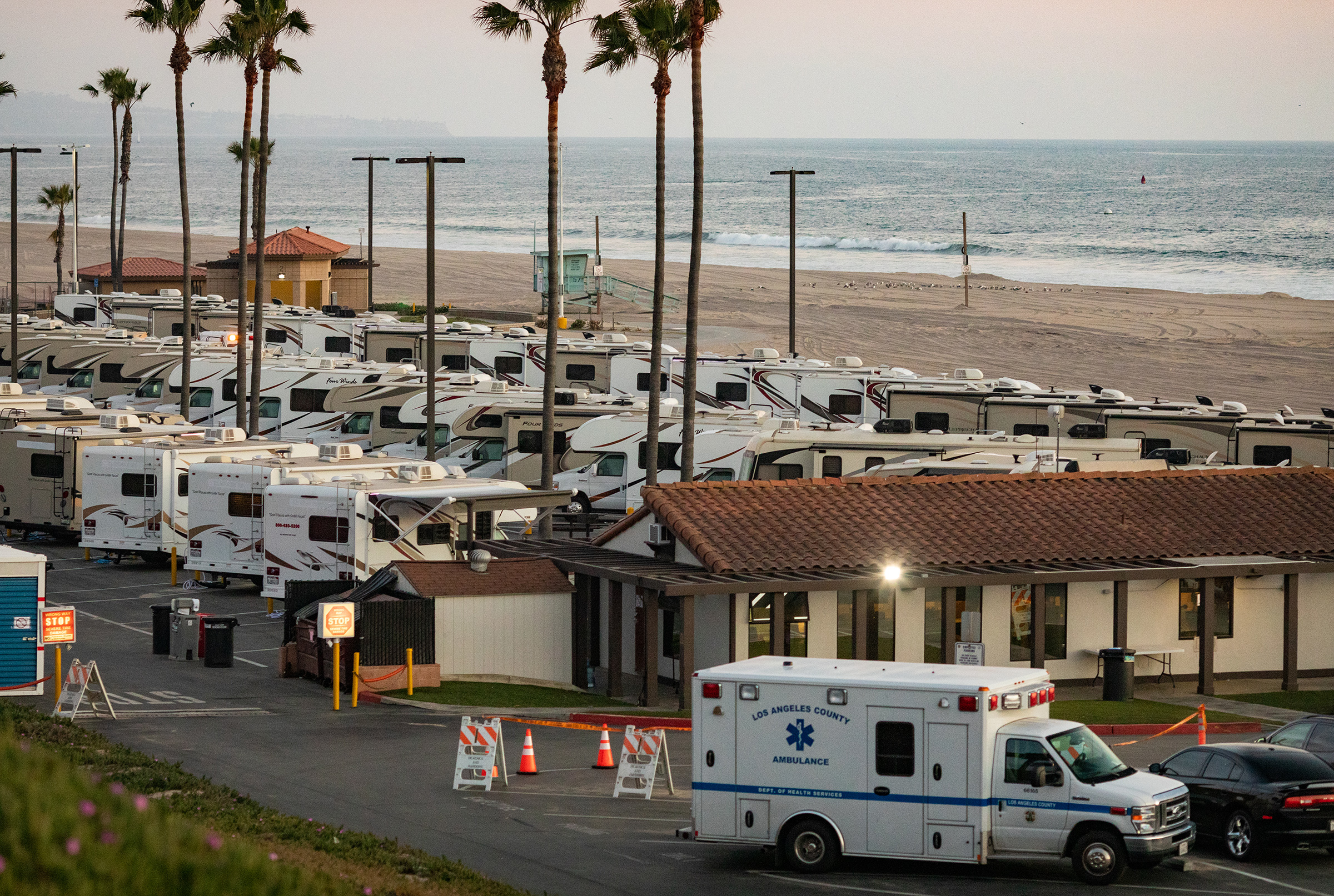 An ambulance arrives in a beachside parking lot being used with R.V's as an isolation zone for people with COVID-19, on April 1st at Dockweiler State Beach in Los Angeles, California (John Fredricks—NurPhoto/Getty Images)
