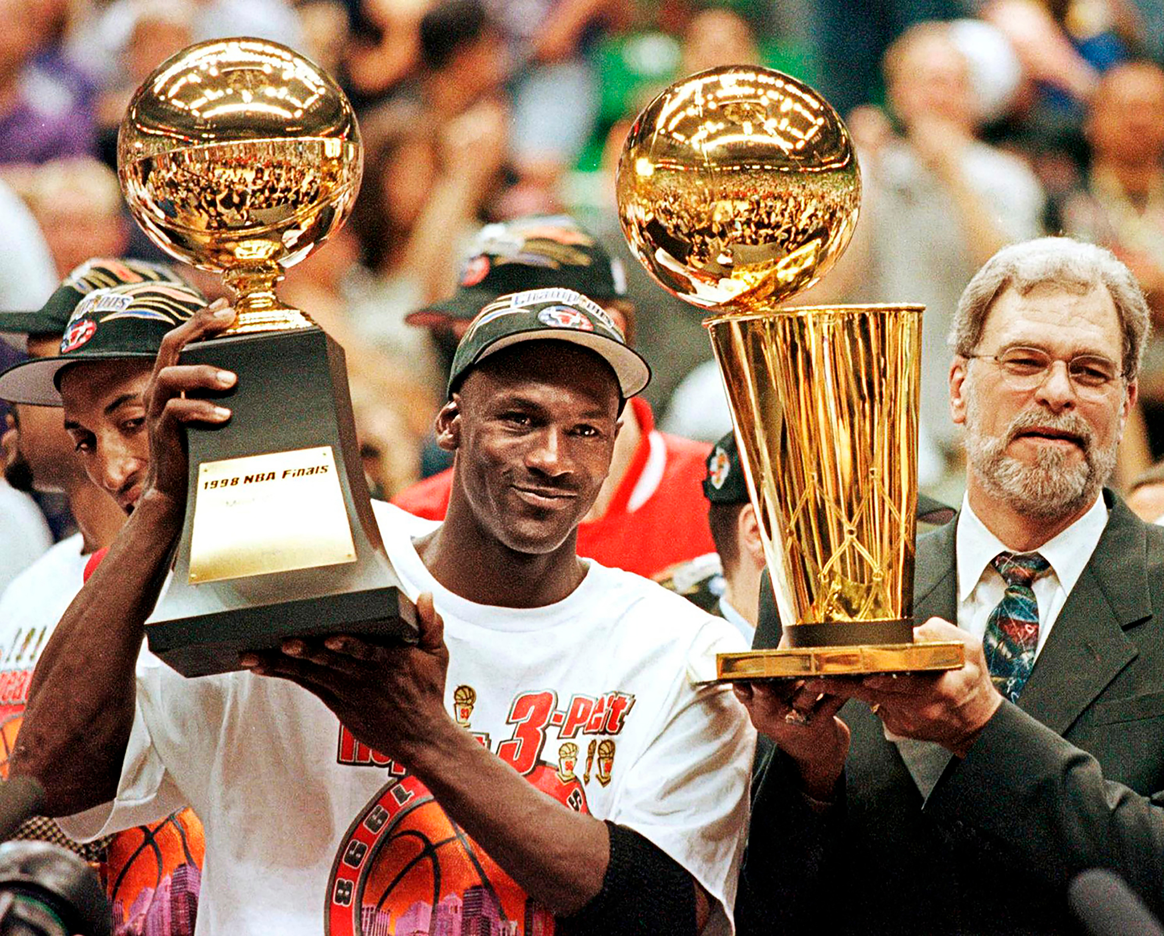 Michael Jordan celebrates his sixth, and final, title with coach Phil Jackson in 1998; both soon leave the Bulls. (Jeff Haynes—AFP via Getty Images)