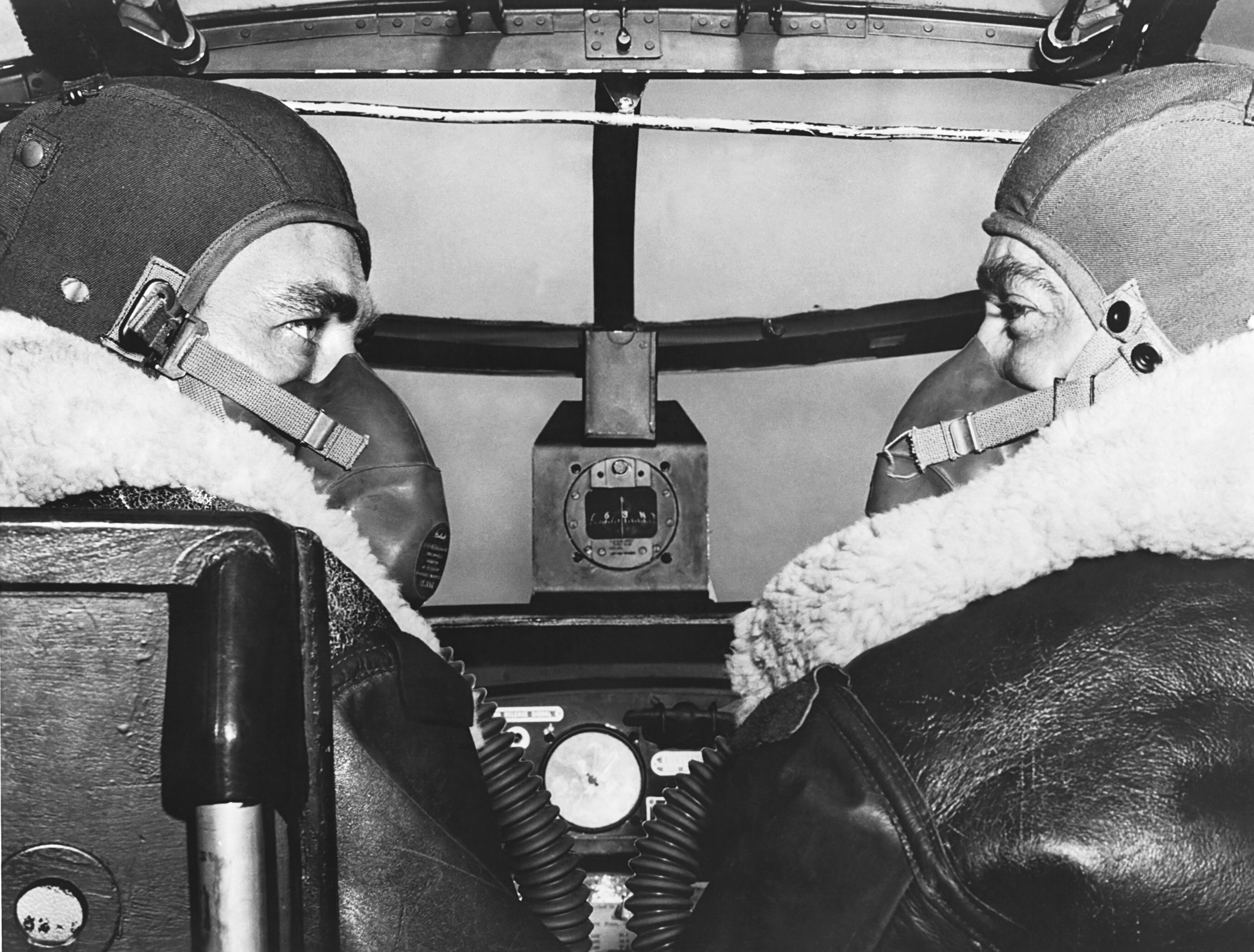 Two aviation cadets from Brooks Field wearing oxygen masks as they pilot a B-25 bomber on a routine high altitude training mission, Fort Worth, Texas, June 1944.