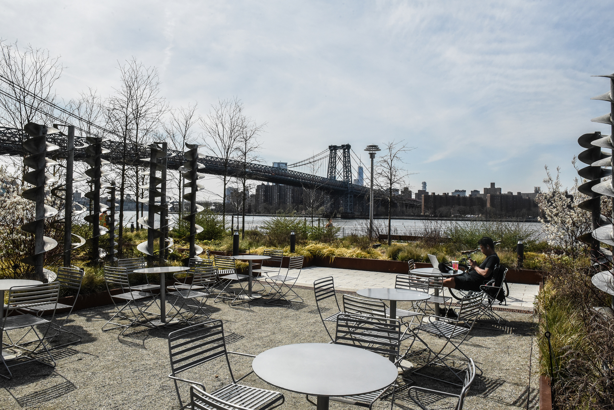 A person sits amongst empty tables and chairs at Domino Park in Williamsburg, Brooklyn on April 7 (Stephanie Keith—Bloomberg/Getty Images)