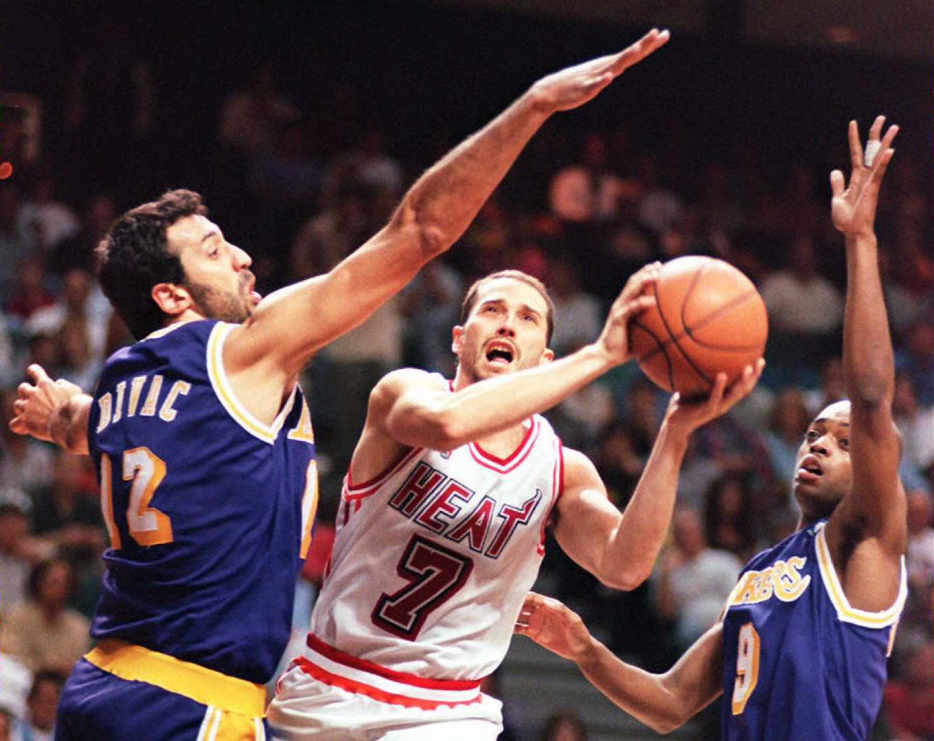 The Miami Heat's Rex Chapman (C) is defended by the Los Angeles Laker's center Vlade Divac (L) and guard Nick Van Exel (R) as he tries to get to the basket in their game 27 March at the Miami Arena. (AFP via Getty Images)