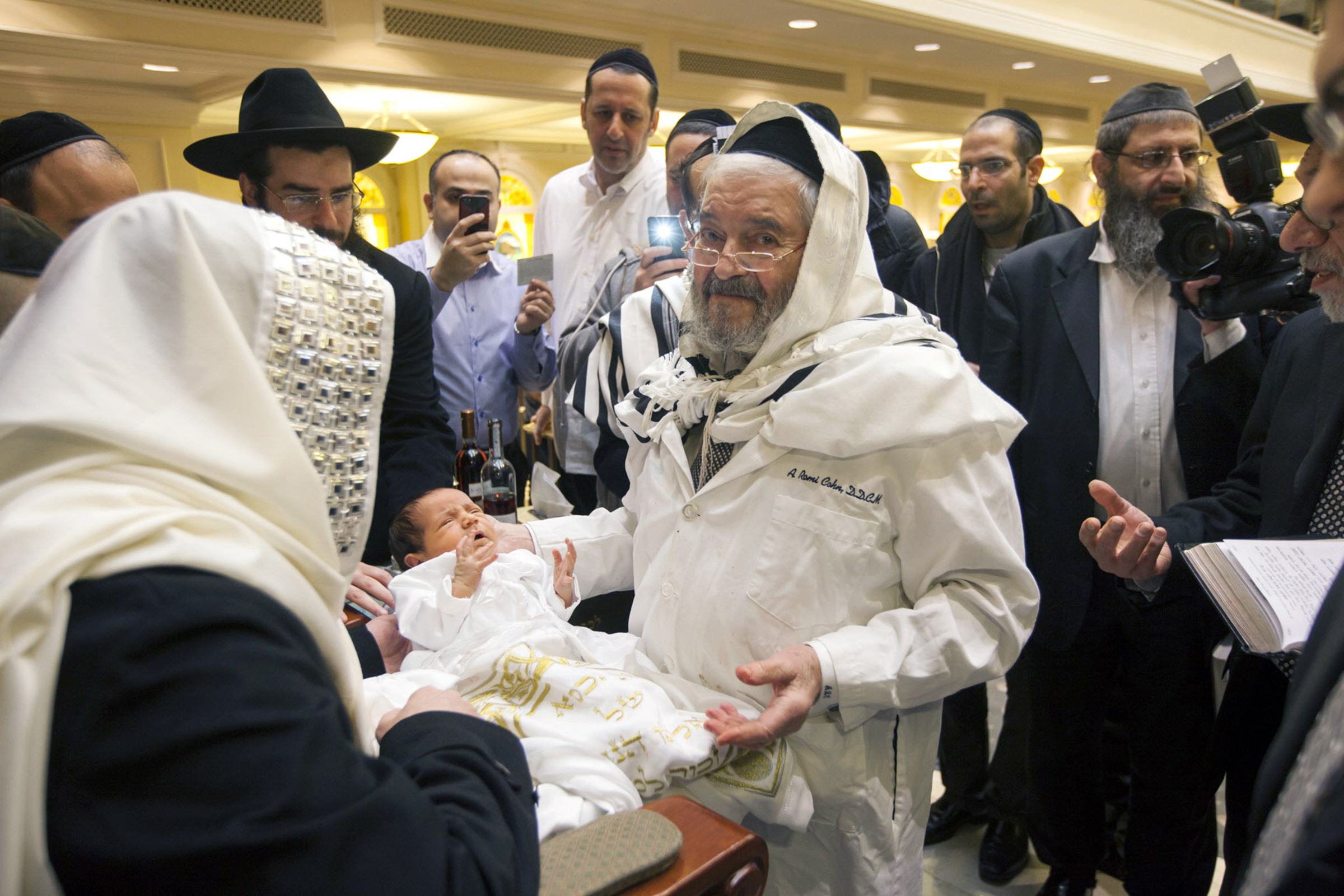 Romi Cohn, born Avraham Hakohen Cohn, performs a circumcision at Congregation Ahaba Ve Ahva in Brooklyn in 2014. (Michael Nagle/The New York Times)