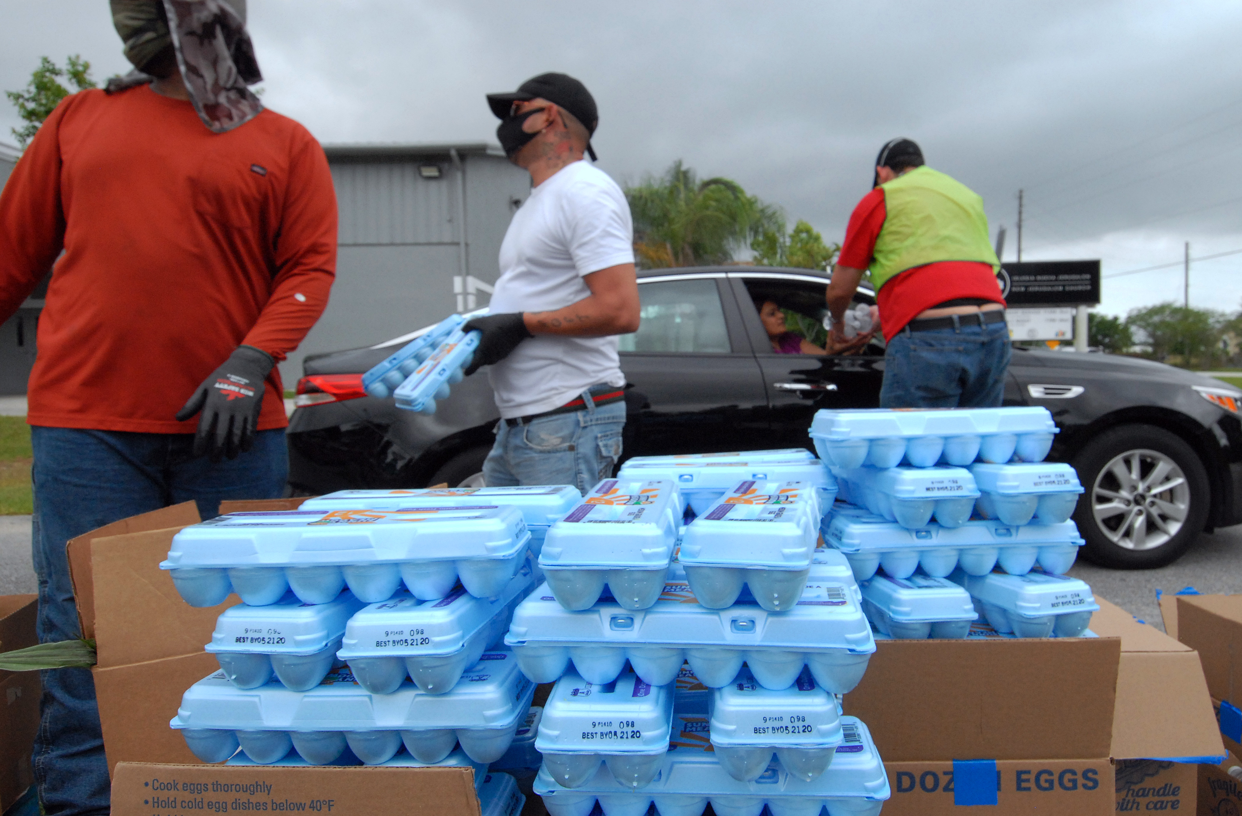 Volunteers distribute eggs from the Second Harvest Food Bank of Central Florida to needy families at a drive through event on April 17, 2020 in Kissimmee, Florida.