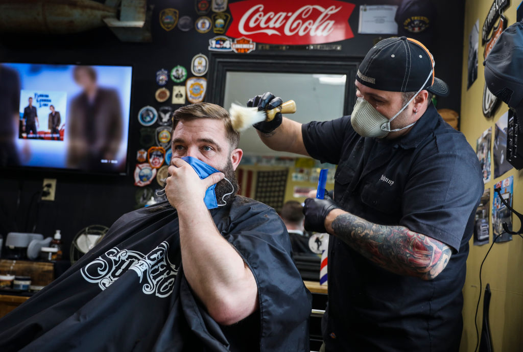 Rusty Razor Barber Shop co-owner John Hopping cuts Norman Bettencourt's hair on the first day of reopening since the coronavirus shutdowns over one month prior in Kittery, ME on May 1, 2020. (Erin Clark/The Boston Globe—Getty Images)