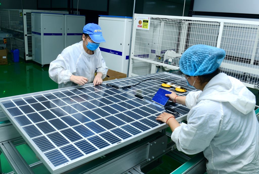 Two workers are on the automatic assembly line to make photovoltaic high-efficiency solar modules in Hai'an City, China, on May 8, 2020. (Costfoto/Barcroft Media/Getty Images)