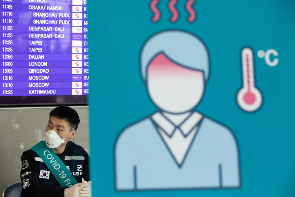 A South Korean soldier wearing a protective mask sits at a temperature screening point at Incheon International Airport in Incheon, South Korea, on Monday, March 9, 2020. (SeongJoon Cho—Bloomberg/Getty Images)