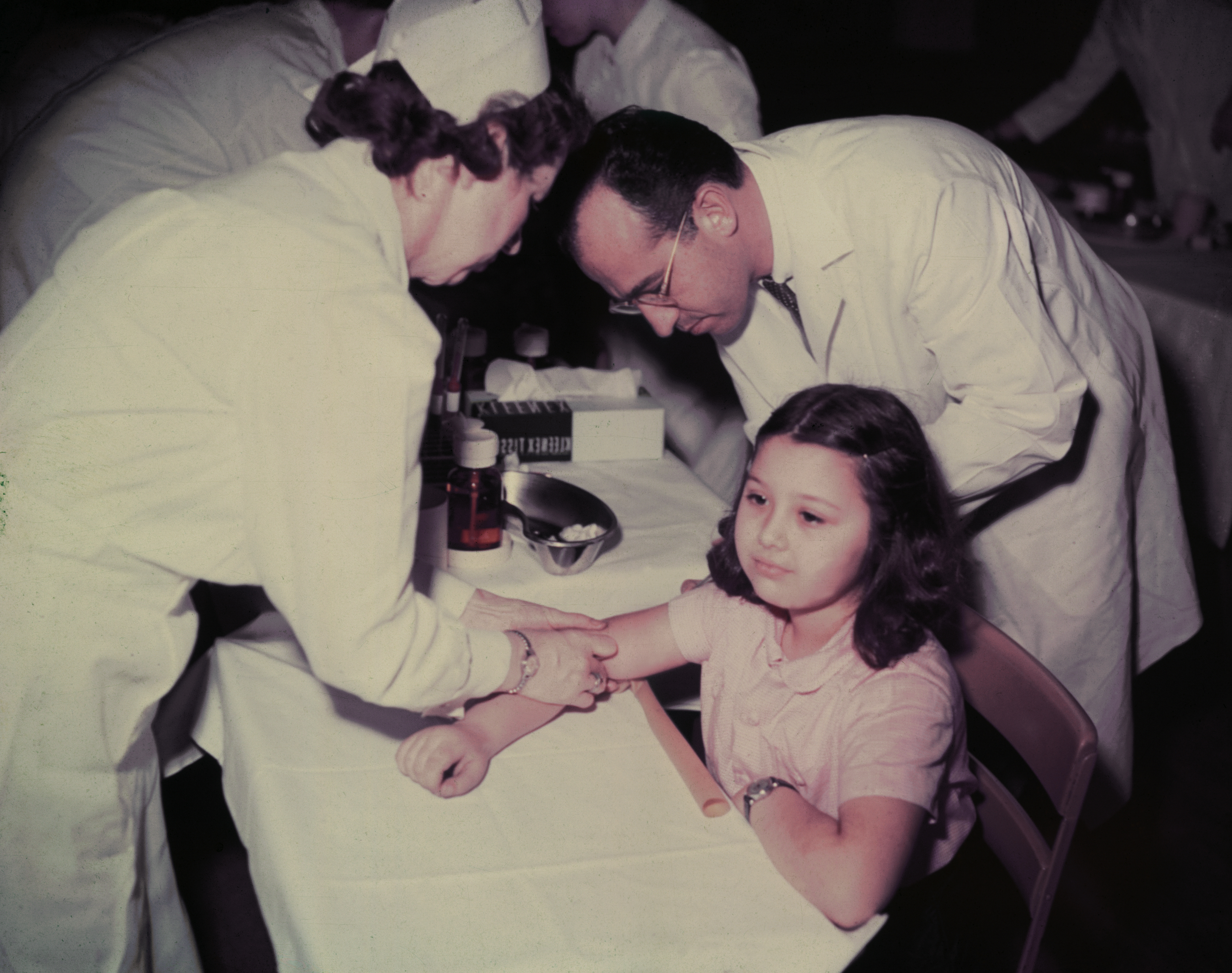 Dr. Jonas E. Salk and a nurse administer a polio vaccine to Pauline Antloger at Sunnyside school in Pittsburgh, Pennsylvania. (Bettmann Archive)