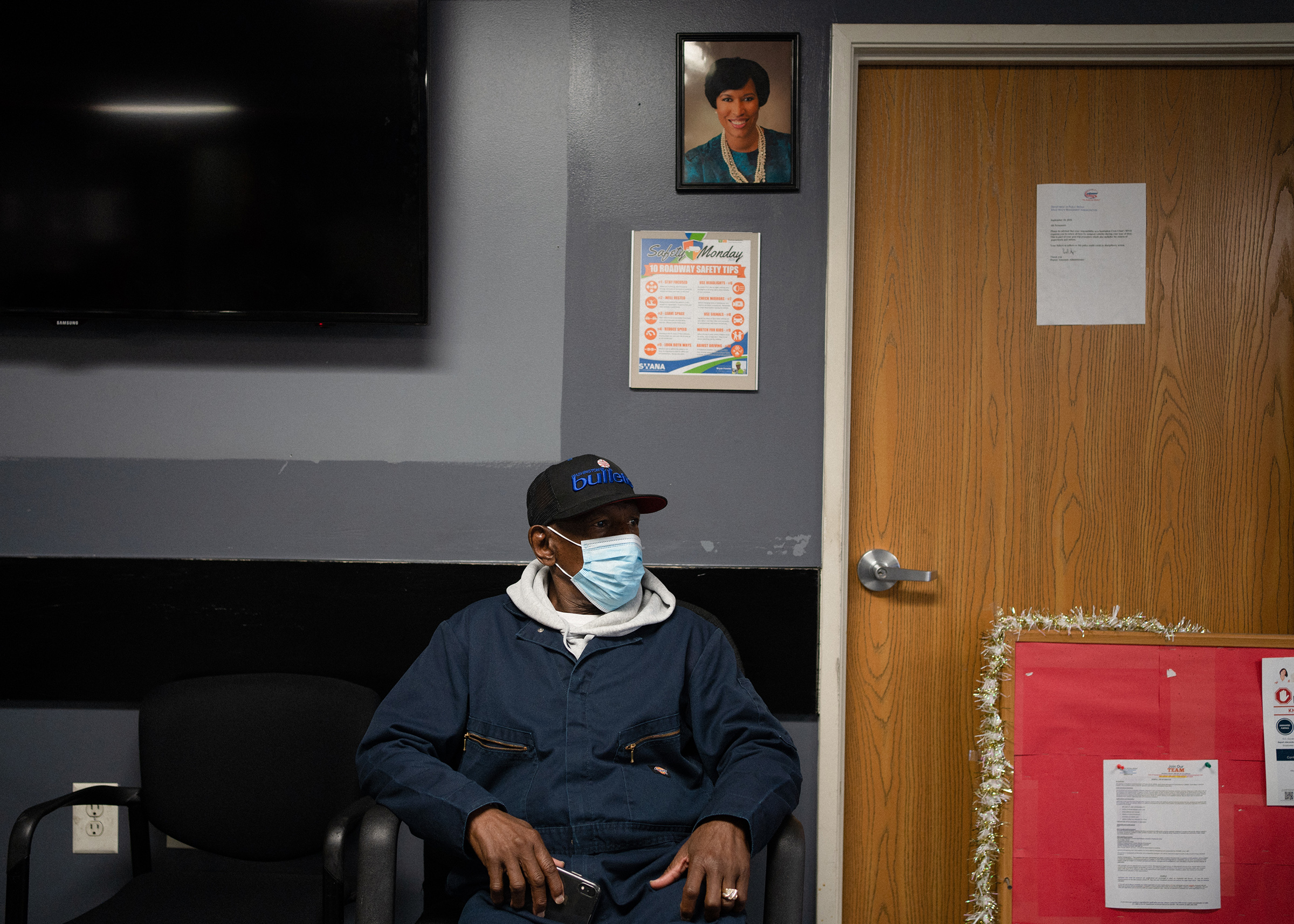 Sanitation Worker, Vincent Walker, 72, sits inside the Larry Hutchins Building at the DC Department of Public Works Solid Waste Collections Division in Northeast Washington, DC, below a portrait of Mayor Muriel Bowser.