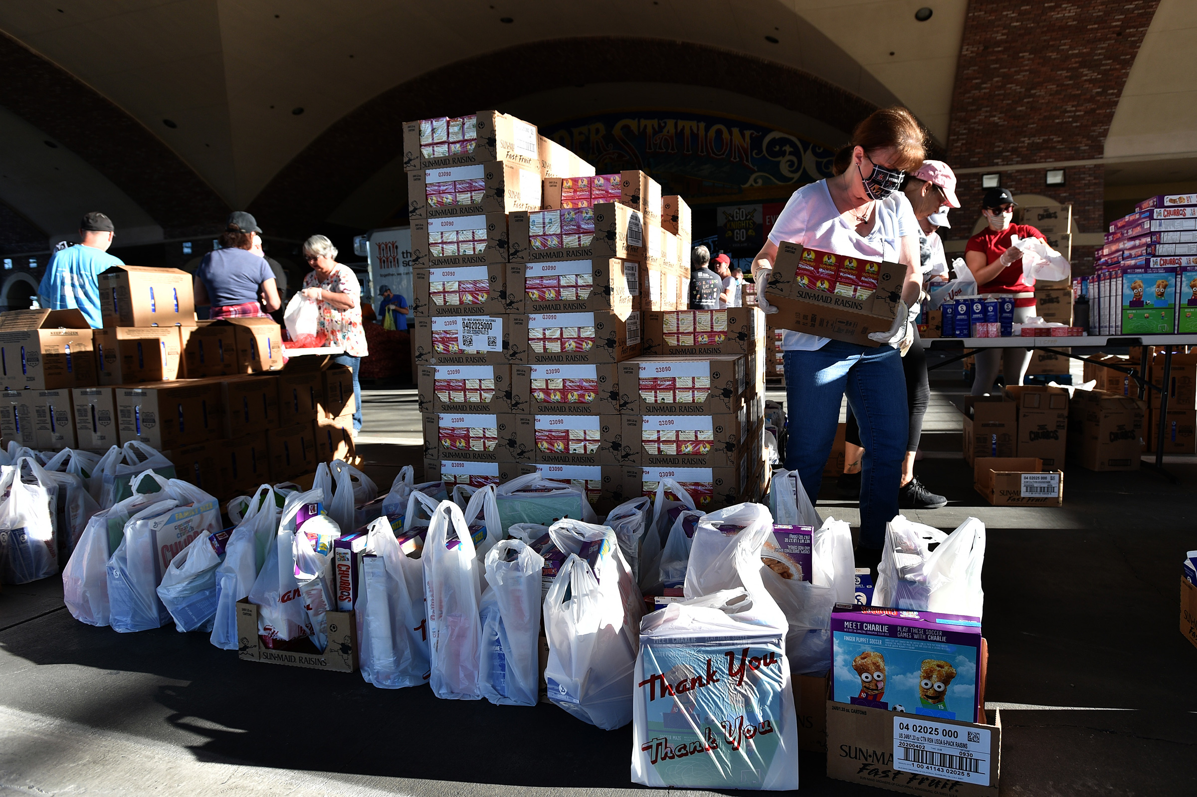 Volunteers prepare groceries to be given out at a drive-thru Three Square Food Bank emergency food distribution site at Boulder Station Hotel &amp; Casino in response to an increase in demand amid the coronavirus pandemic on April 29 in Las Vegas. (David Becker—AFP/Getty Images)