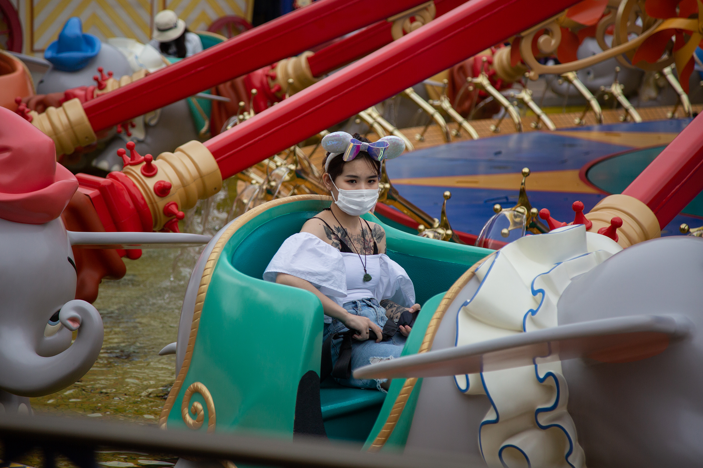 A visitor sits on the Dumbo the Flying Elephant attraction at Shanghai Disneyland on May 11, the day it reopened.