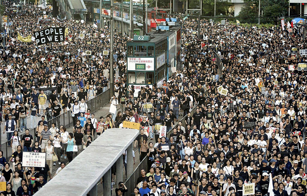 Trams sit stranded as thousands of people block the streets in a huge protest march against a controversial anti-subversion law known as Article 23 in Hong Kong on July 1, 2003. (Peter Parks—AFP/Getty Images)