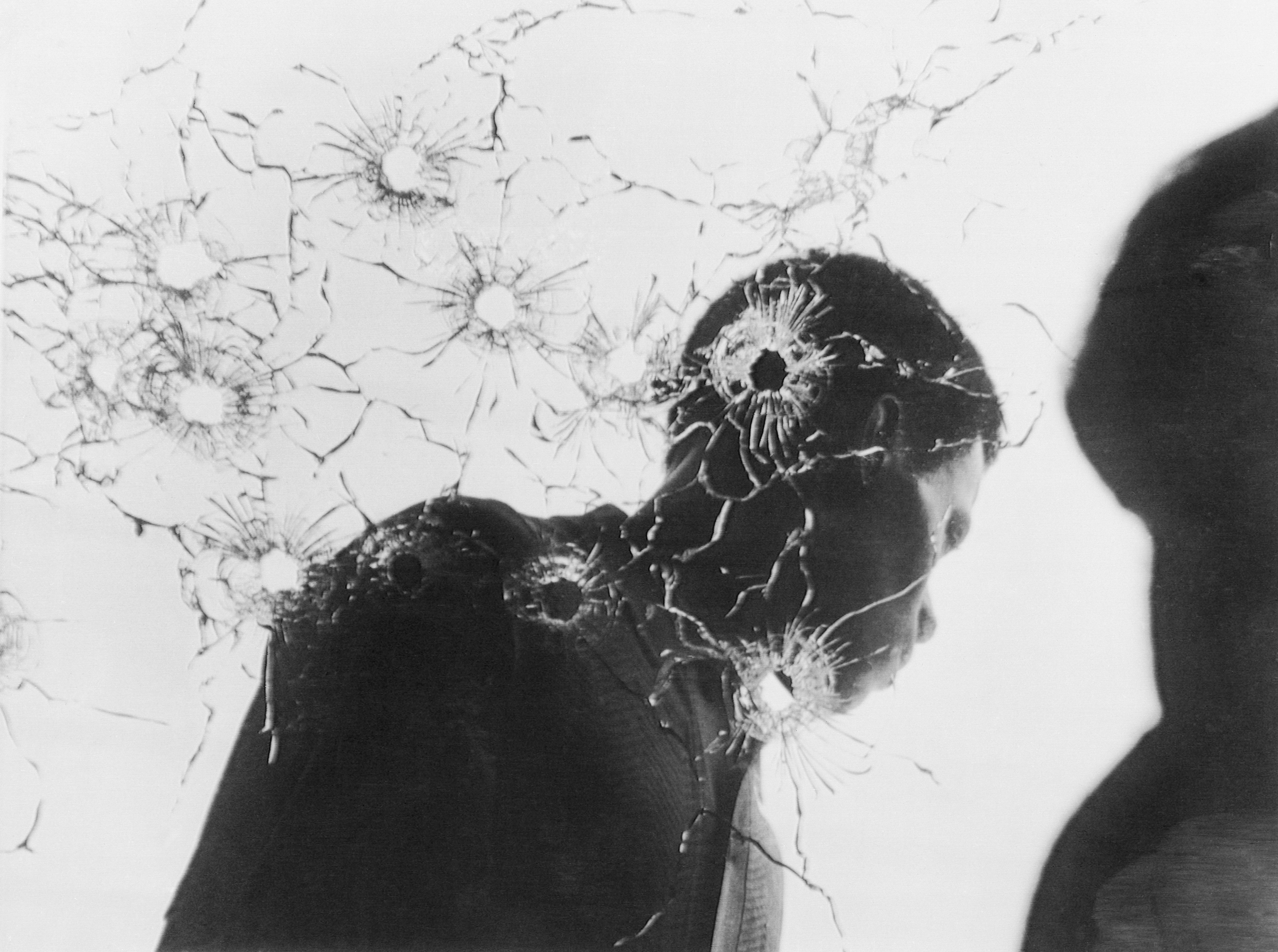 May 16, 1970 - Jackson, Miss: A man stands behind the shattered window of a women's dormitory following the fatal shooting of two students at Jackson State College. (Bettmann Archive)