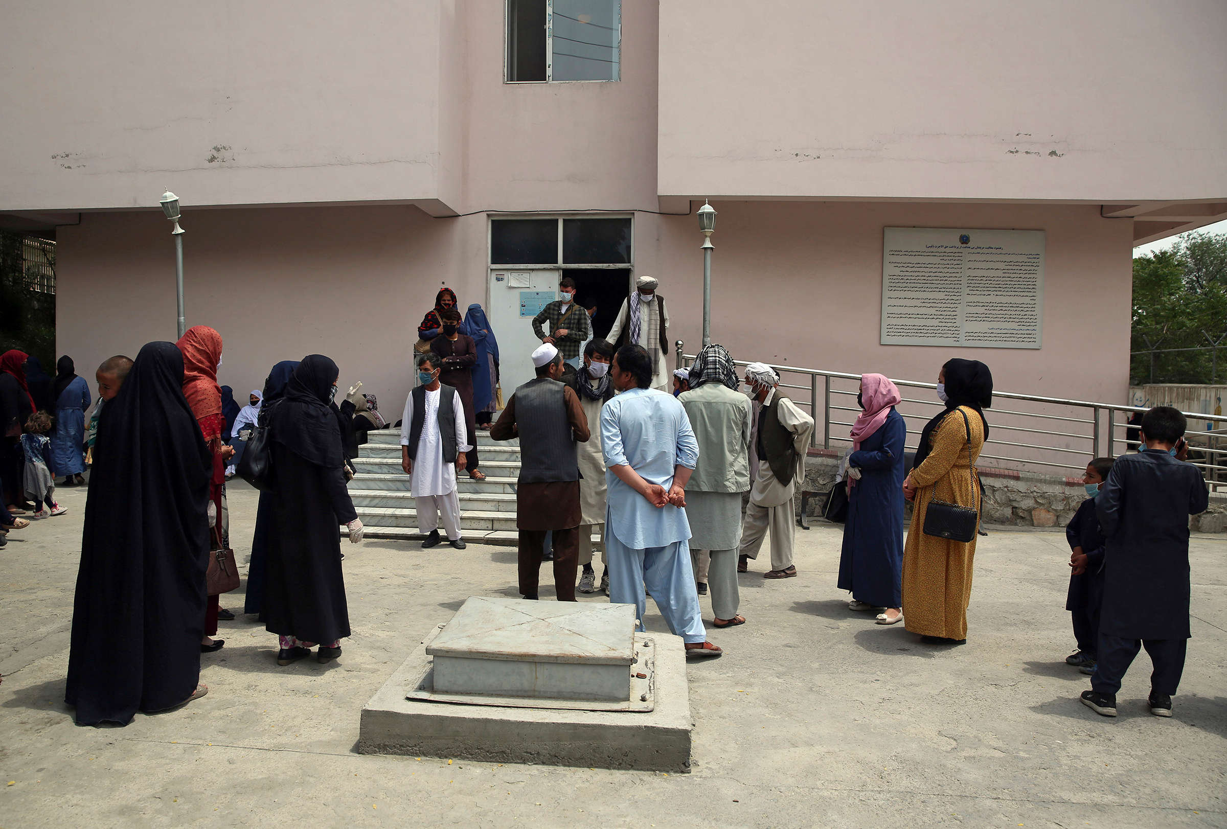 Families of newborn babies wait outside the Ataturk hospital to see their children, a day after they were rescued following a deadly attack on another maternity hospital, in Kabul on May 13.