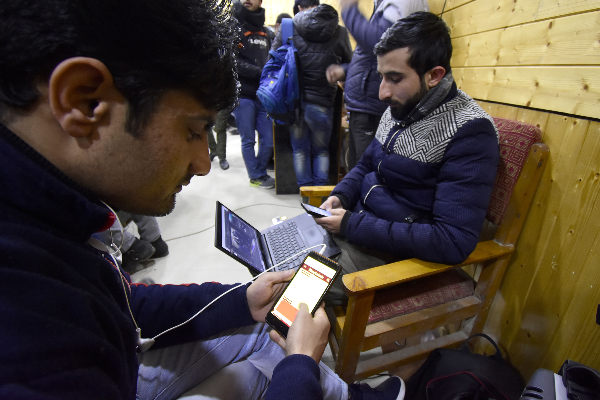 Kashmiri people look at their mobile phones after authorities restored low speed mobile internet services in the Kashmir Valley on Jan. 25, 2020. (Muzamil Mattoo—NurPhoto via Getty Images)