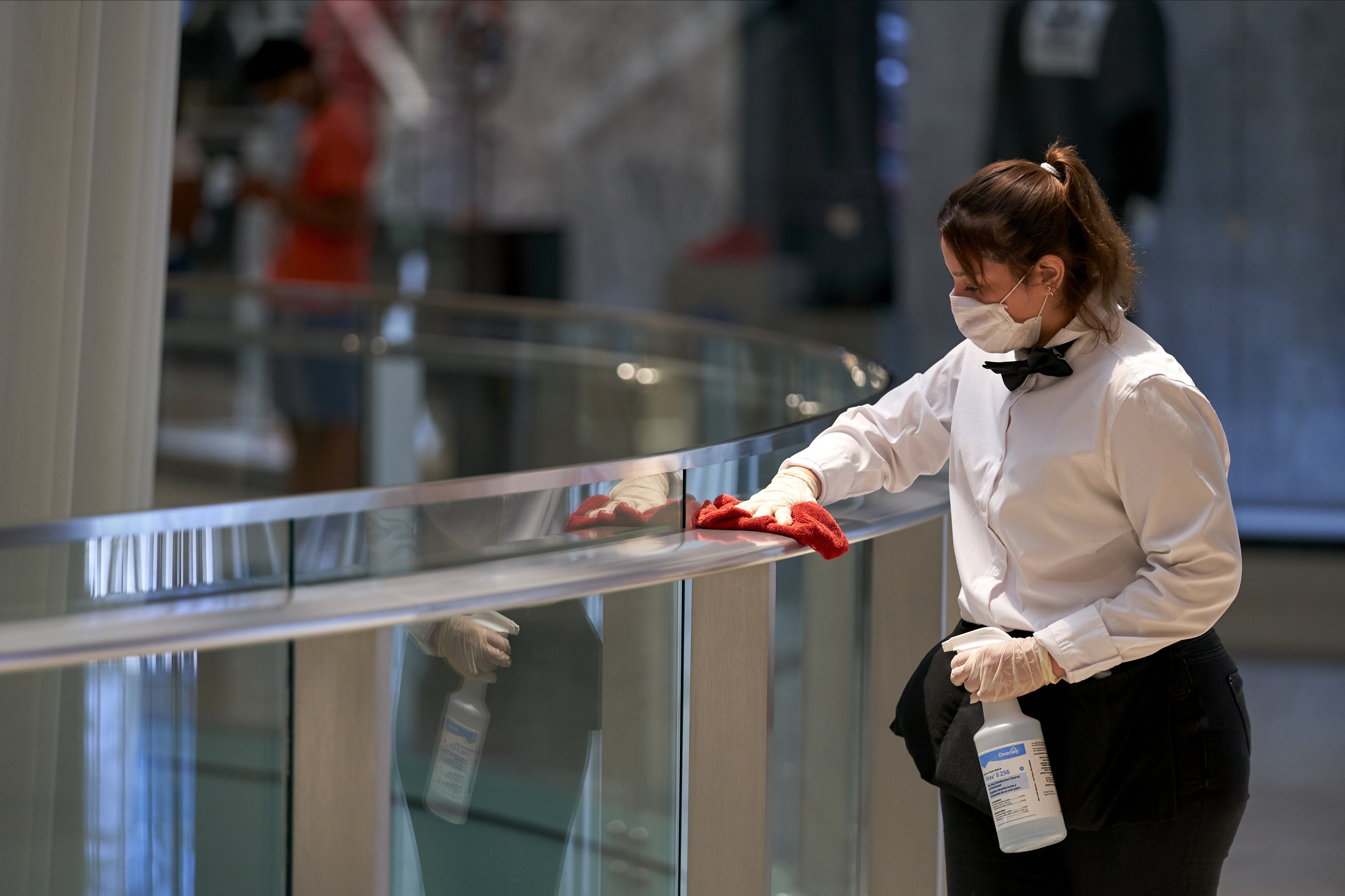A worker disinfects hand rails at the Galleria Dallas mall in Dallas, Texas on May 4, 2020. (Cooper Neill—Bloomberg/Getty Images)