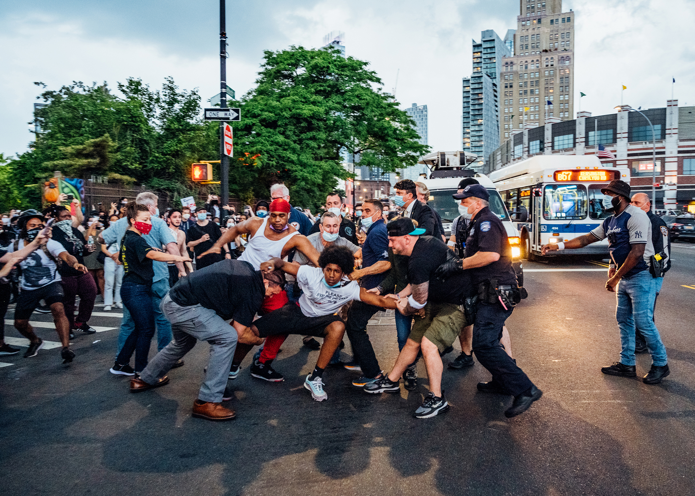 A protester, wearing a shirt that reads "Please Stop the Violence," is dragged near Brooklyn's Barclays Center on May 29, four days after George Floyd's death. (Malike Sidibe for TIME)