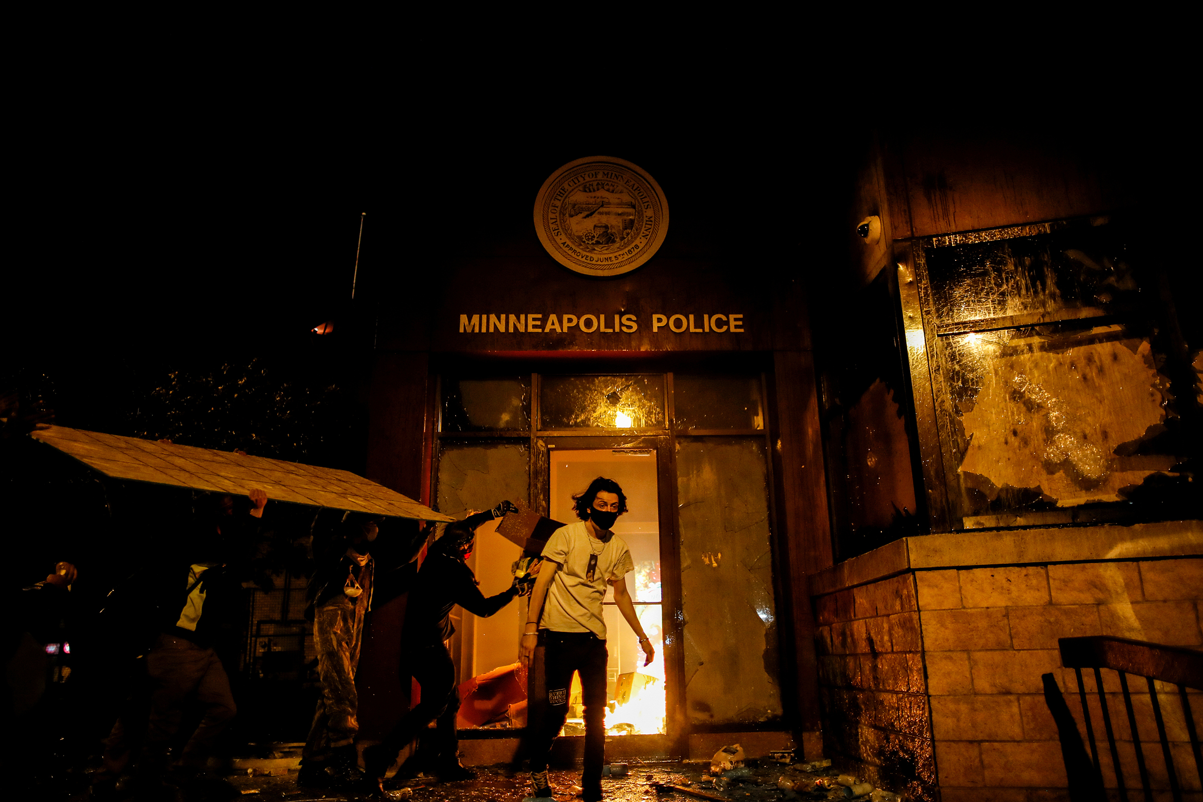 Protesters set fire to the entrance of a police station as demonstrations continue in Minneapolis