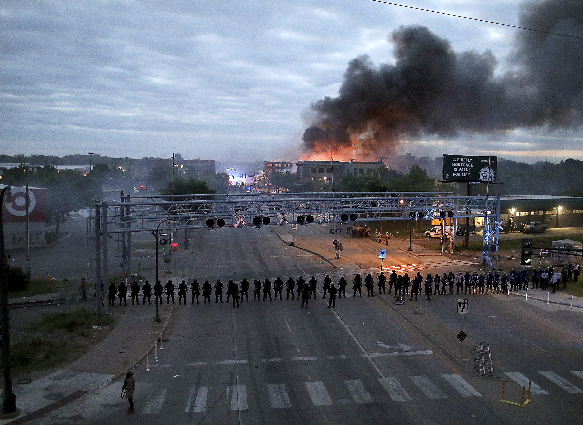 Law enforcement officers amassed along Lake Street near Hiawatha Ave. as fires burned after a night of unrest and protests in the death of George Floyd in Minneapolis, Minn. on May 29. (David Joles—Star Tribune/AP)