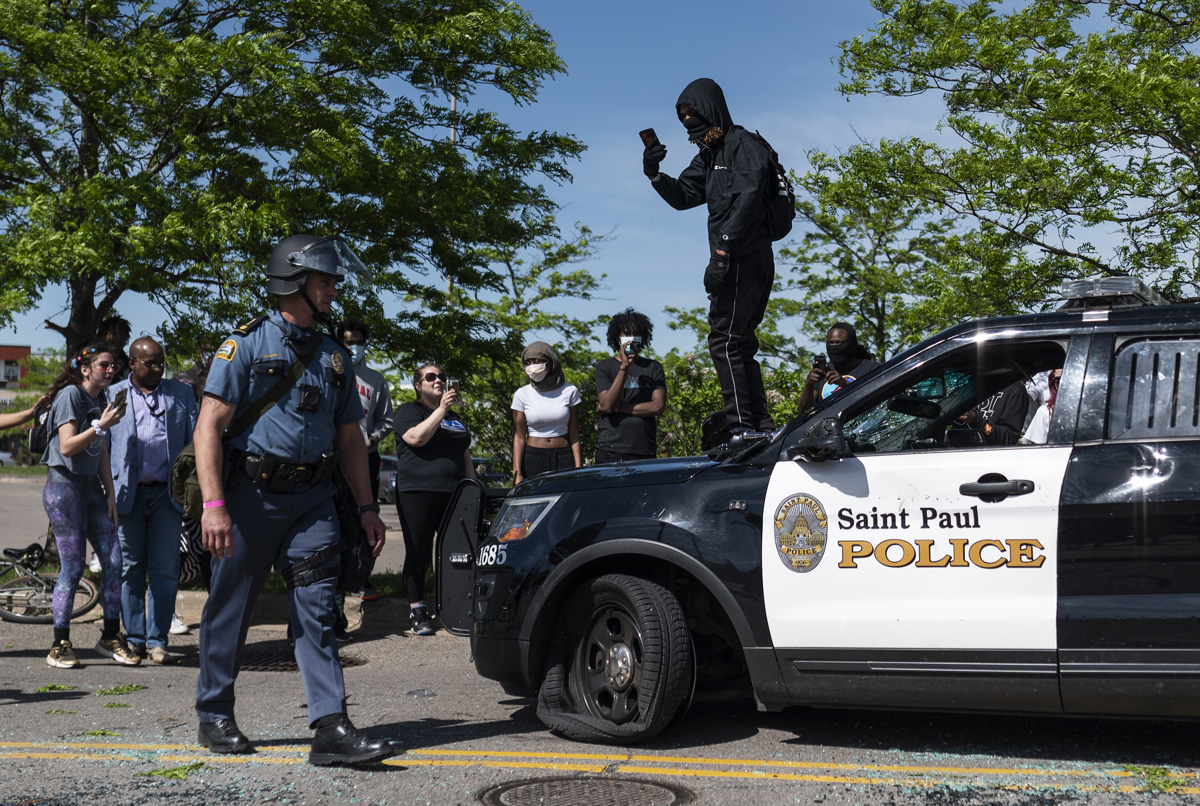 A protester confronts a police officer while standing on a destroyed cruiser in St. Paul on May 28. (Stephen Maturen—Getty Images)