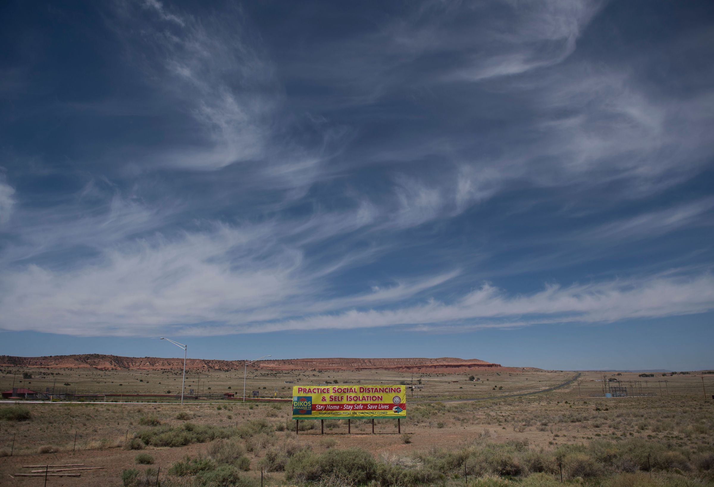 A sign promoting social distancing sits near the Navajo Nation town of Chinle during the 57 hour curfew imposed to try to stop the spread of the Covid-19 virus through the Navajo Nation, in Arizona on May 23, 2020.