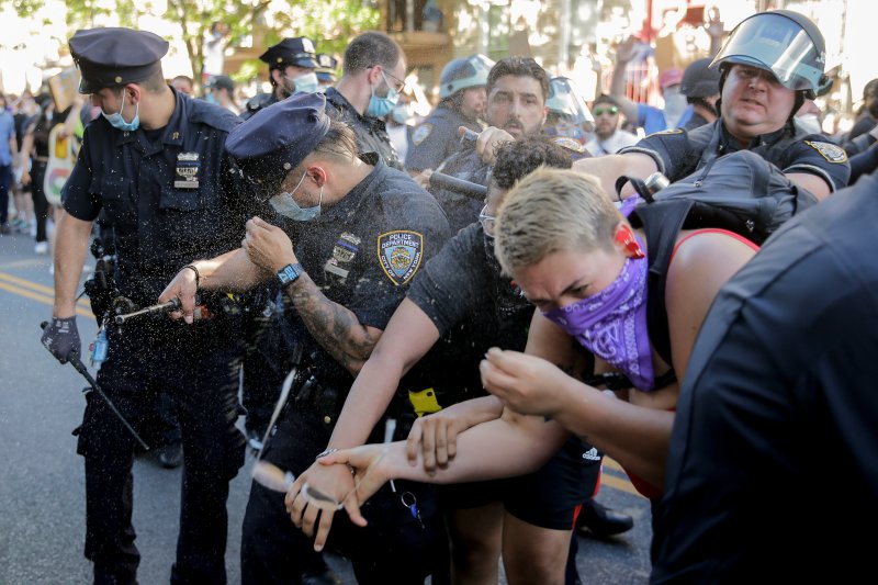 New York Police officers use pepper spray on protesters during a demonstration May 30, 2020, in the Brooklyn borough of New York.