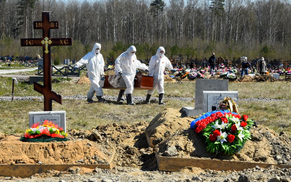 Cemetery workers wearing protective gear bury a coronavirus victim at a cemetery on the outskirts of Saint Petersburg on May 6, 2020. (OLGA MALTSEVA/AFP via Getty Images)