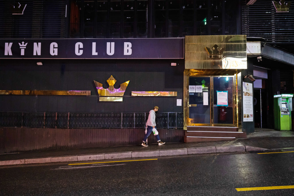 A person wearing a protective face mask walks past a closed club at night in the Itaewon area of Seoul, South Korea, on Saturday, May 9, 2020. (SeongJoon Cho–Bloomberg/Getty Images)