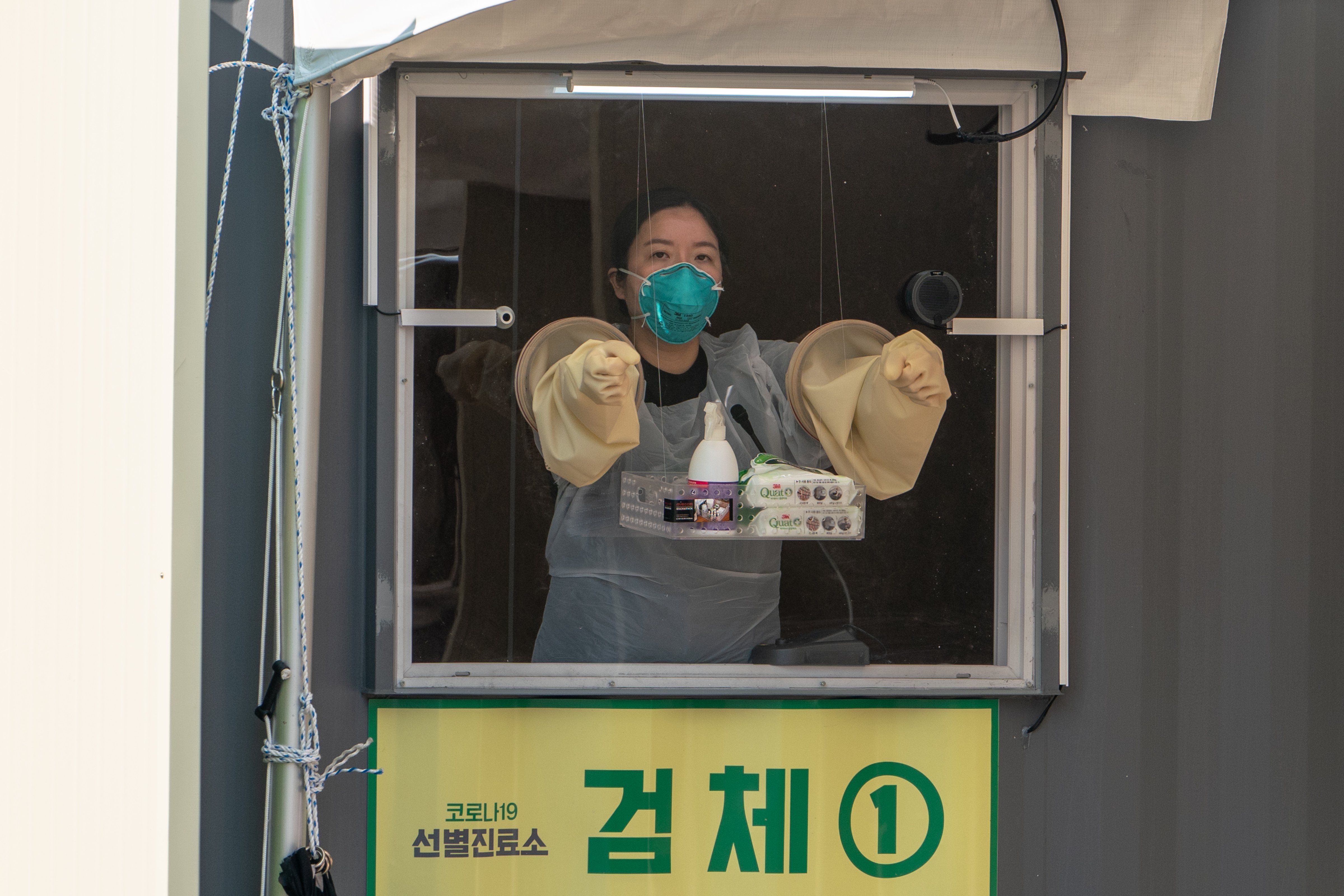 A health care worker  at the sample collection point at a "walk thru" testing center in Seoul, South Korea. (Simon Shin—SOPA Images/LightRocket/Getty Images)