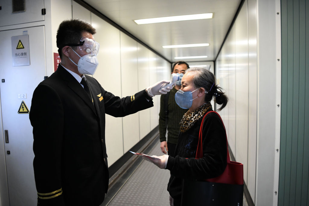 A passenger boarding a Shenzhen Airlines flight has temperature checked at the Baoan International Airport in Shenzhen, China, on April 8, 2020. (Liang Xu—Xinhua News Agency/Getty Images)