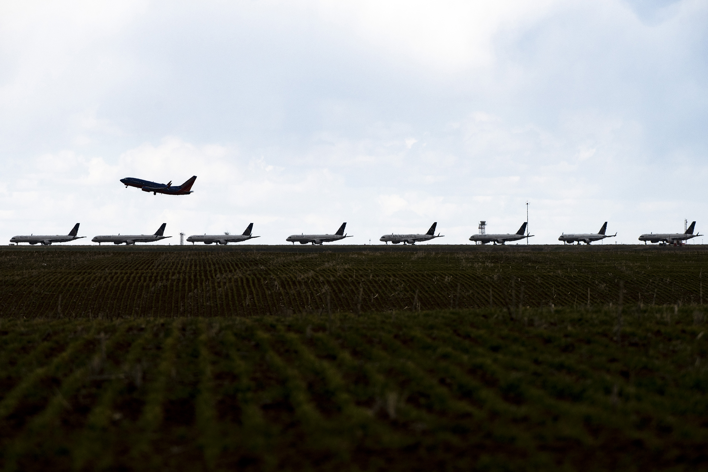 A Southwest Airlines flight takes off as United Airlines planes sit parked on a runway at Denver International Airport on April 22, 2020 in Denver, Colorado. (Michael Ciaglo—Getty Images)