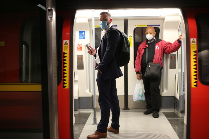Passengers wearing face masks travel on a London Underground Tube train, in the evening rush hour at Waterloo station on May 11, 2020