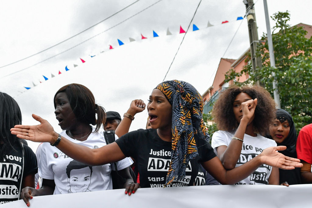 Assa Traore (C), the elder sister of late Adama Traore, who died during his arrest by the police in July 2016, wearing a tee-shirt reading 'Justice for Adama, without justice, you won't have peace' delivers a speech during a commemorative march on July 22, 2017 in Beaumont-sur-Oise, northeast of Paris. (Julien Mattia—Getty)