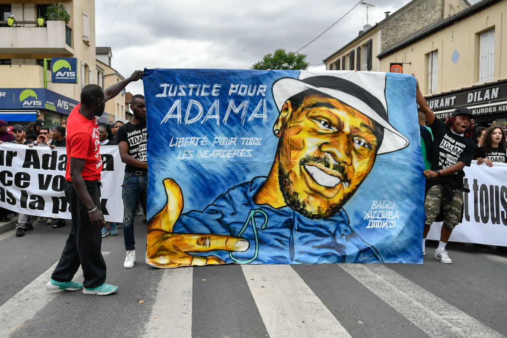 People raise their fists as they take part in a march in memory of Adama Traore, who died during his arrest by the police in July 2016, on July 22, 2017 in Beaumont-sur-Oise, northeast of Paris. (Julien Mattia—Getty)