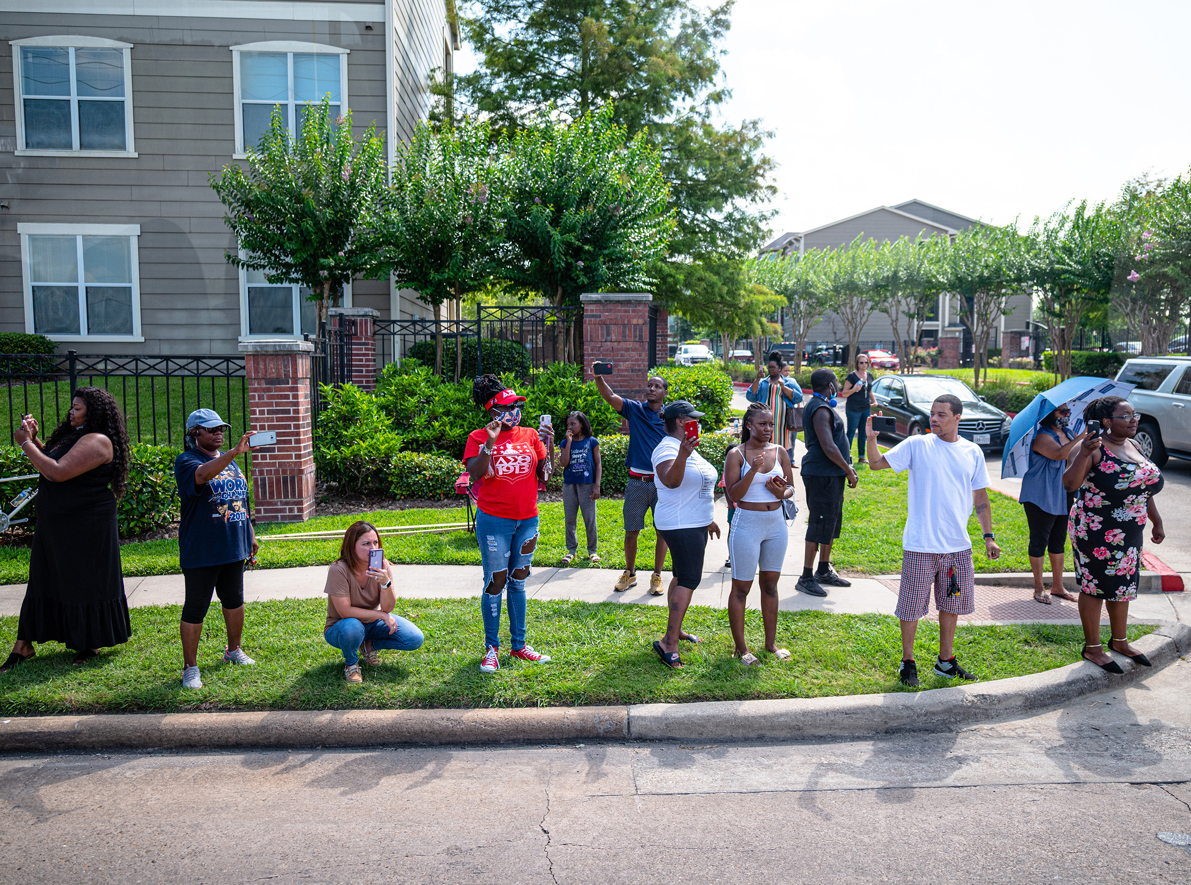 Onlookers document the passing of George Floyd’s funeral procession on June 9. (Ruddy Roye for TIME)