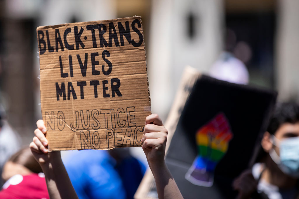 A Caucasian protester holds up their homemade sign on a box that says, "Black Trans Lives Matter No Justice No Peace" during a protest at Trump Tower in the Manhattan Borough of New York on June 12, 2020. (Ira L. Black—Corbis via Getty Images)