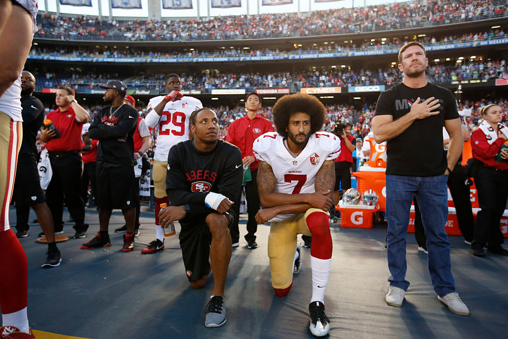 Eric Reid #35 and Colin Kaepernick #7 of the San Francisco 49ers kneel on the sideline during the anthem, as free agent Nate Boyer stands, prior to the game against the San Diego Chargers at Qualcomm Stadium on September 1, 2016 in San Diego, California. (Michael Zagaris—San Francisco 49ers/Getty Images)