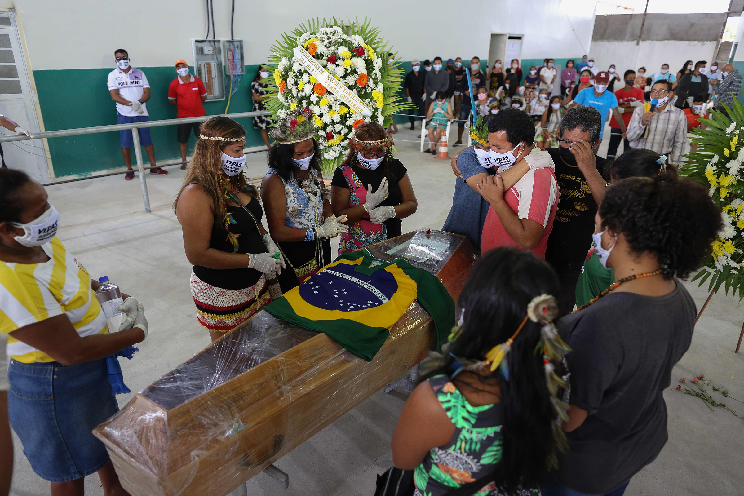 Indigenous from the Parque das Tribos community mourn besides the coffin of Chief Messias, 53, of the Kokama tribe who died victim of the new coronavirus, COVID-19, in Manaus, Brazil, on May 14, 2020. (Michael Dantas—AFP/Getty Images)