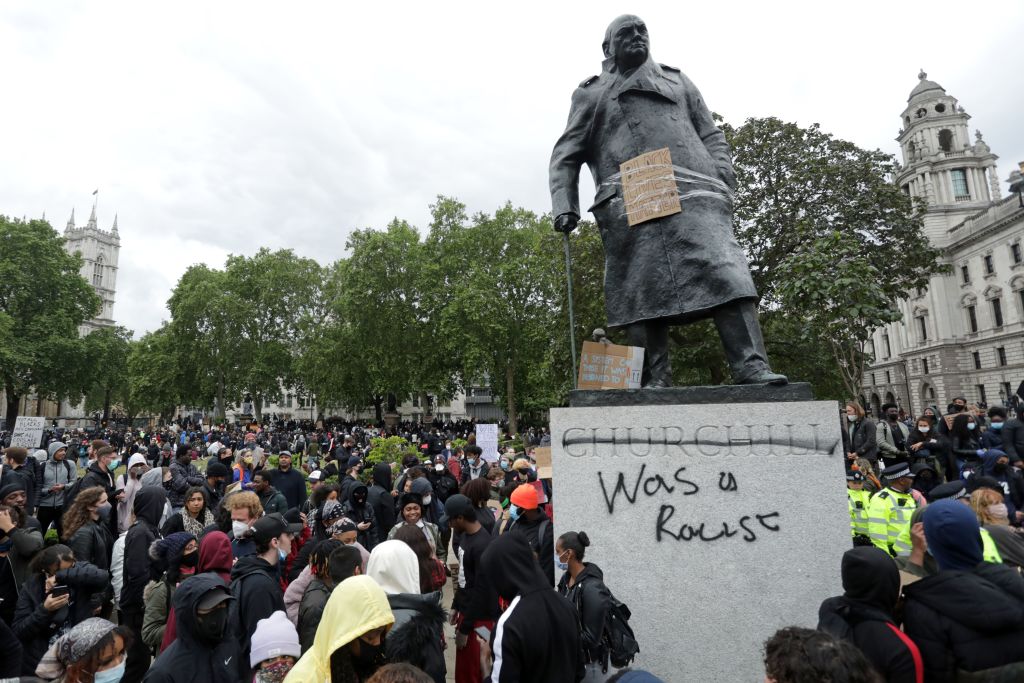 The statue of former British prime minister Winston Churchill is seen defaced, with the words (Churchill) "was a racist" written on its base in Parliament Square, central London after a demonstration outside the U.S. Embassy, on June 7, 2020, organized to show solidarity with the Black Lives Matter movement. (Isabel Infantes/AFP via Getty Images)