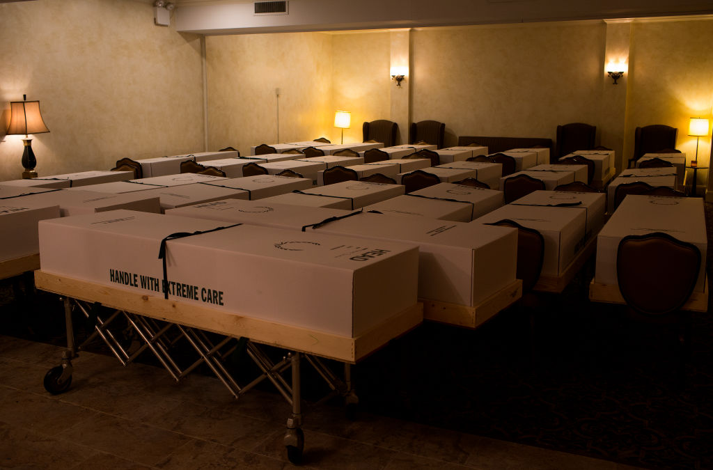 A funeral home in the epicenter of the COVID-19 pandemic deals with an excess of recent deaths because of the virus by storing bodies in the chapel and loading them up into a truck to ship to crematoriums and cemeteries on May 11, 2020 in the Elmhurst neighborhood of Queens, New York. (Andrew Lichtenstein—Corbis/Getty Images)