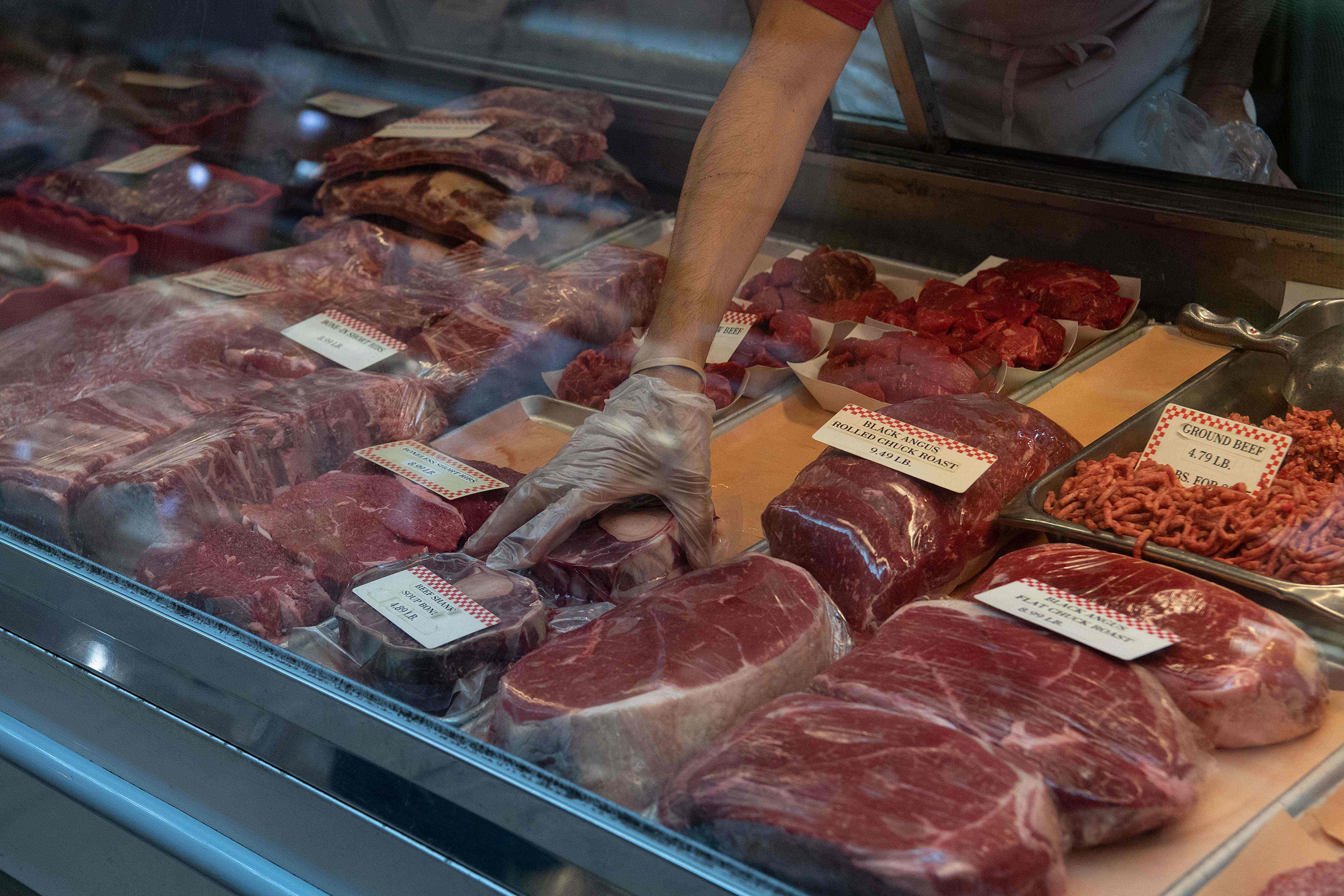A butcher picks up a cut of beef at Eastern Market in Washington, D.C., on May 5 (Nicholas Kamm—AFP/Getty Images)
