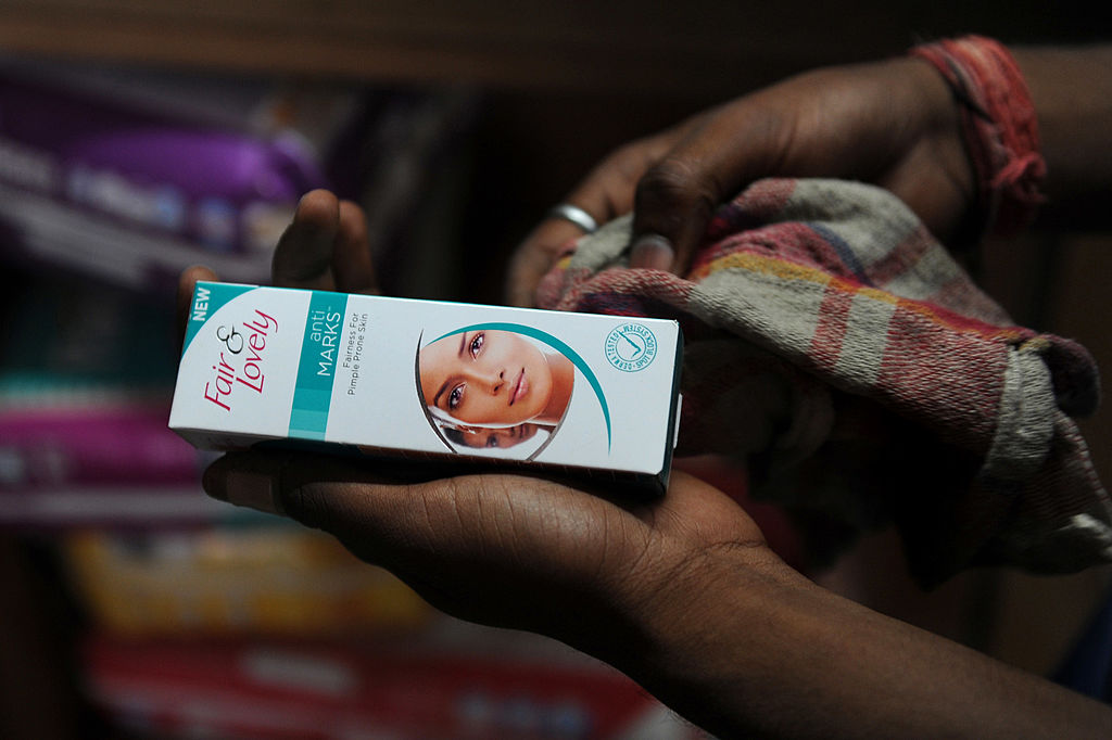 A sales assistant wipes Unilever product, Fair and Lovely skin fairness cream at a shop in New Delhi on April 30, 2013. (SAJJAD HUSSAIN—AFP/ Getty Images)