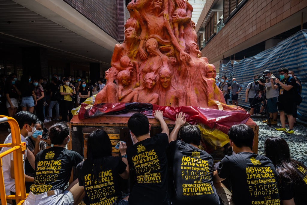 Students clean the Pillar of Shame, a memorial for those killed in the 1989 Tiananmen crackdown, at the University of Hong Kong on June 4, 2020.