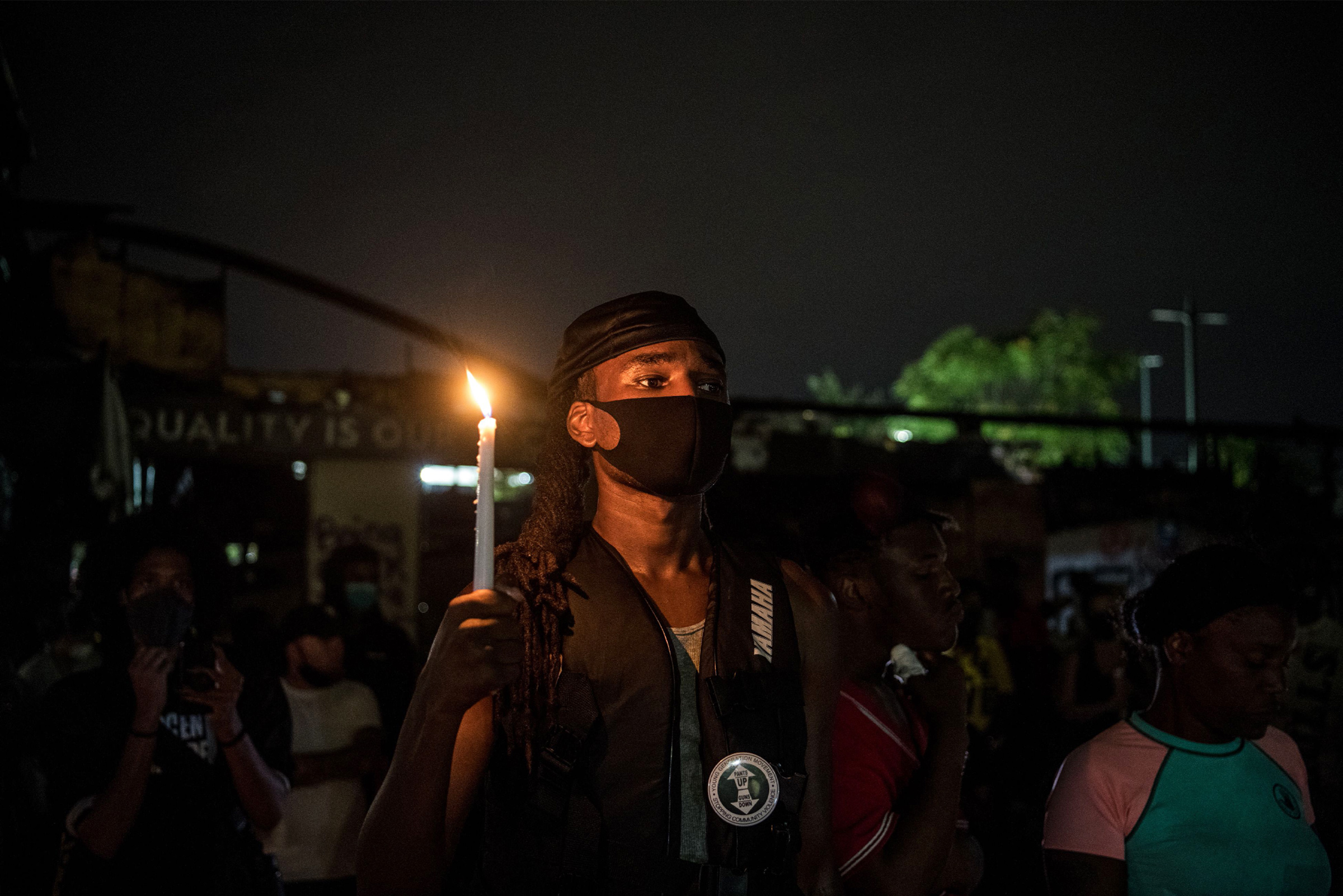 A protester holds a candle following Rayshard Brooks’ death in Atlanta, on June 15