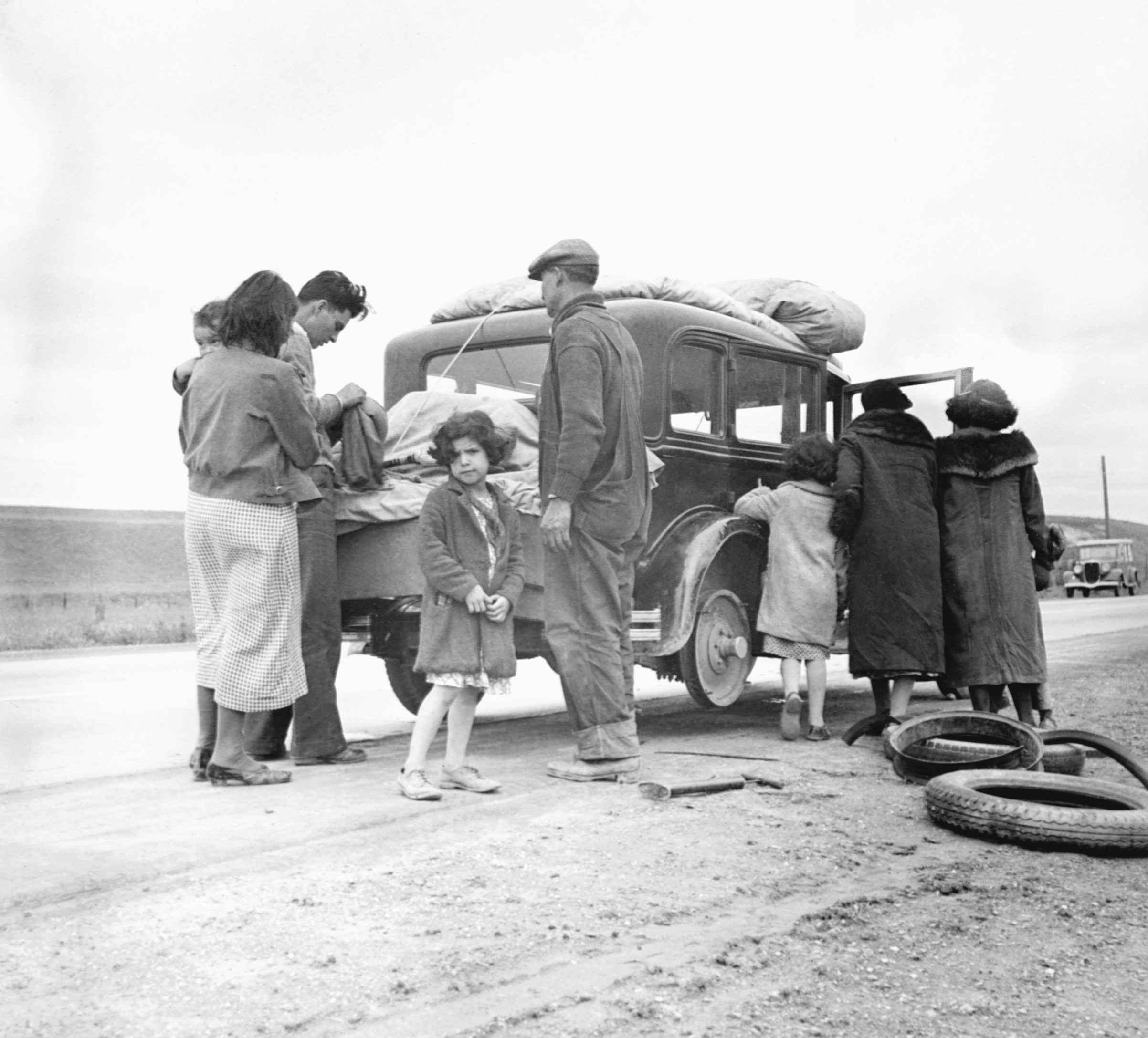 Migrant family from Mexico fixing a tire in California, February 1936. (Corbis via Getty Images)