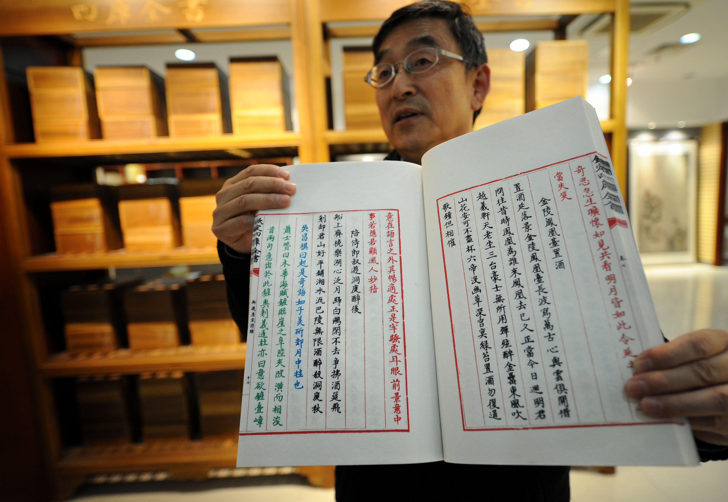 Lu Guobin, manager of Yangzhou Bindings, shows the duplicate of a classic Chinese book, the "Siku Quanshu," or the "Complete Library in the Four Branches of Literature," in Yangzhou on April 17, 2014. (Xinhua/Alamy)