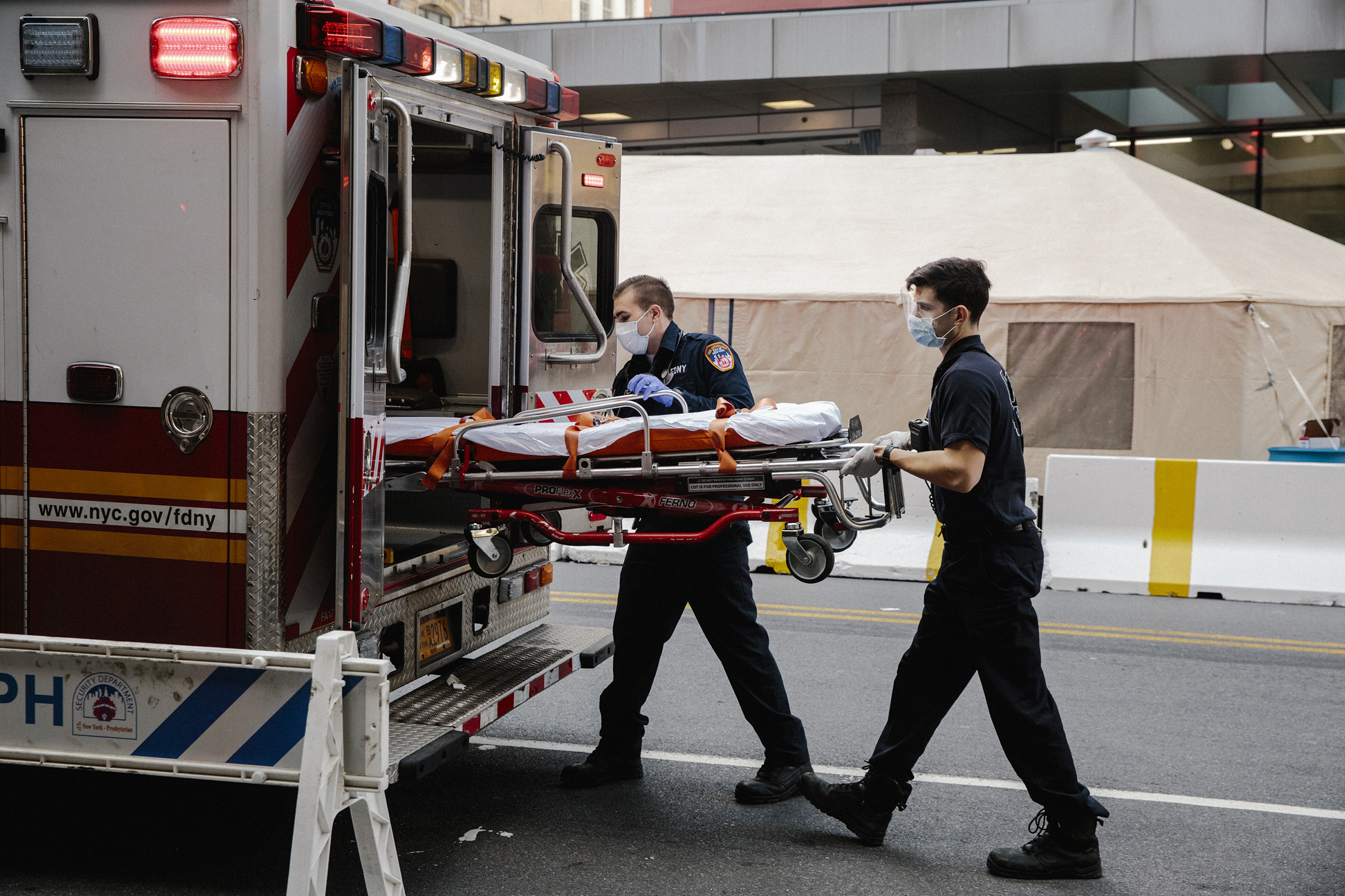 Emergency medical technicians after transporting a possible coronavirus patient outside of New York Presbyterian Lower Manhattan Hospital, on March 26, 2020. (Mark Abramson—The New York Times/Redux)
