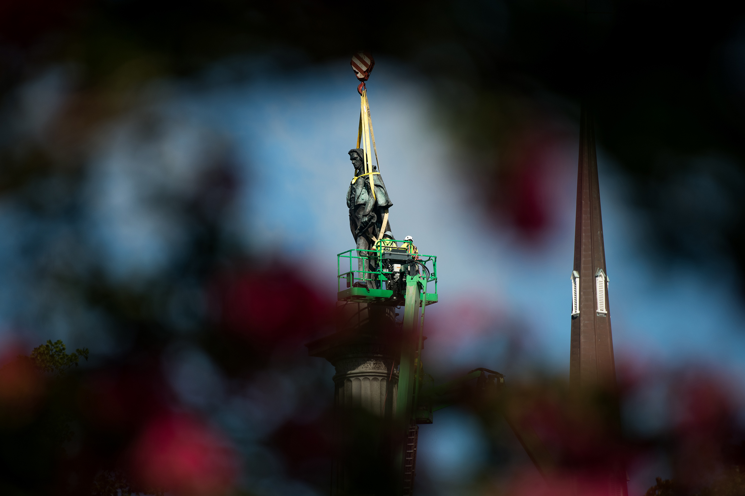 Workers dismantle the John C. Calhoun statue atop a monument in Marion Square in Charleston, S.C., on June 24, 2020.