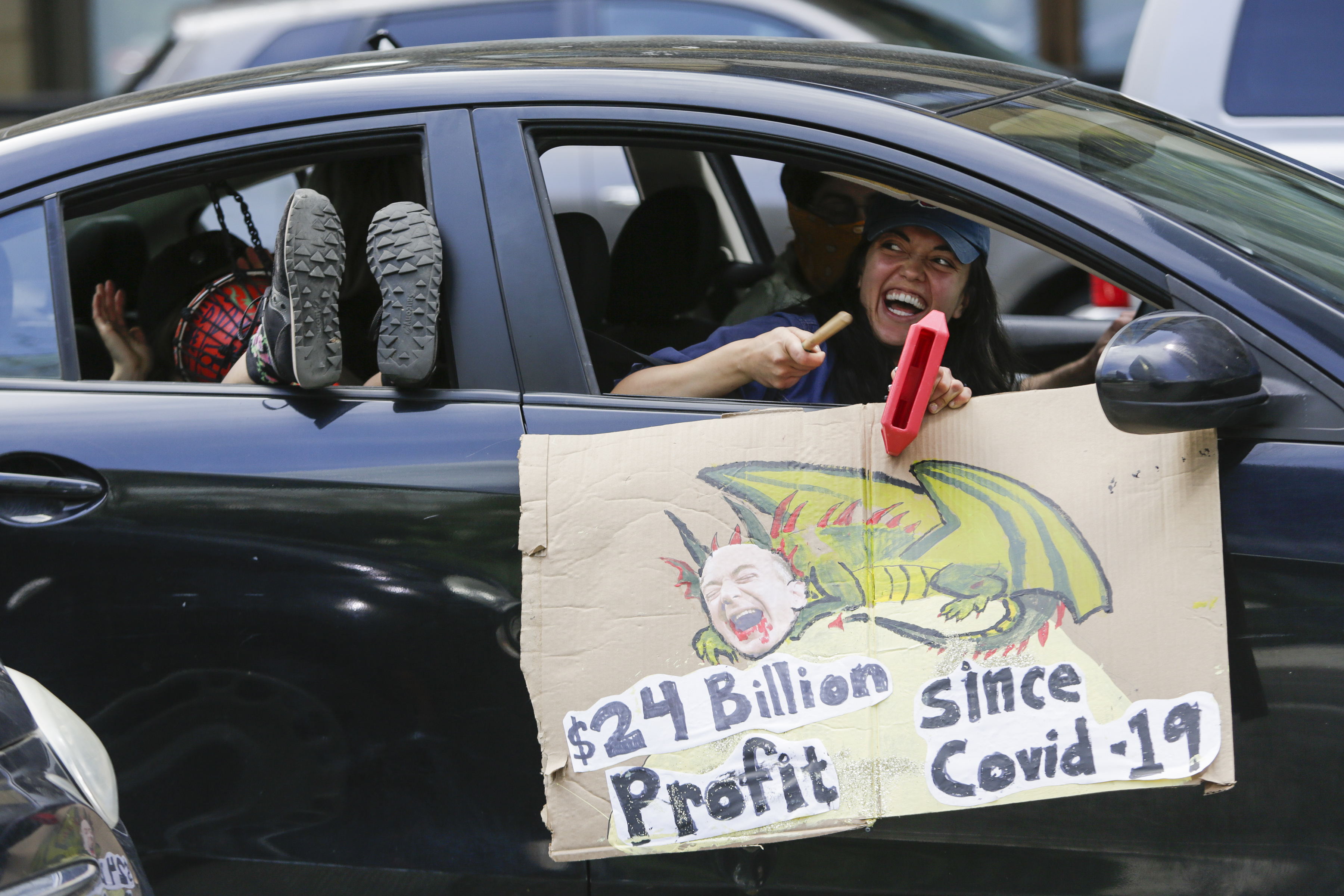 Protesters wave signs critical of Amazon founder Jeff Bezos's growing wealth during a car caravan outside Amazon headquarters in Seattle, Wash., on May 1, 2020. (Jason Redmond—AFP/Getty Images)