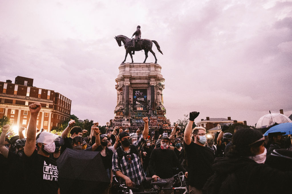 Protesters raise their fists in the air in front of Richmond, Va.'s, Robert E. Lee statue on June 23. (Eze Amos—Getty Images)