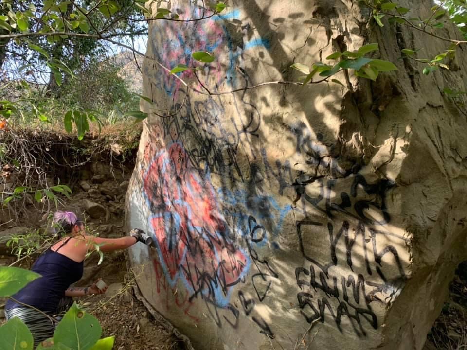A volunteer works to remove graffiti from the Santa Paula Canyon in Ventura County, Calif. (Ellie Mora)